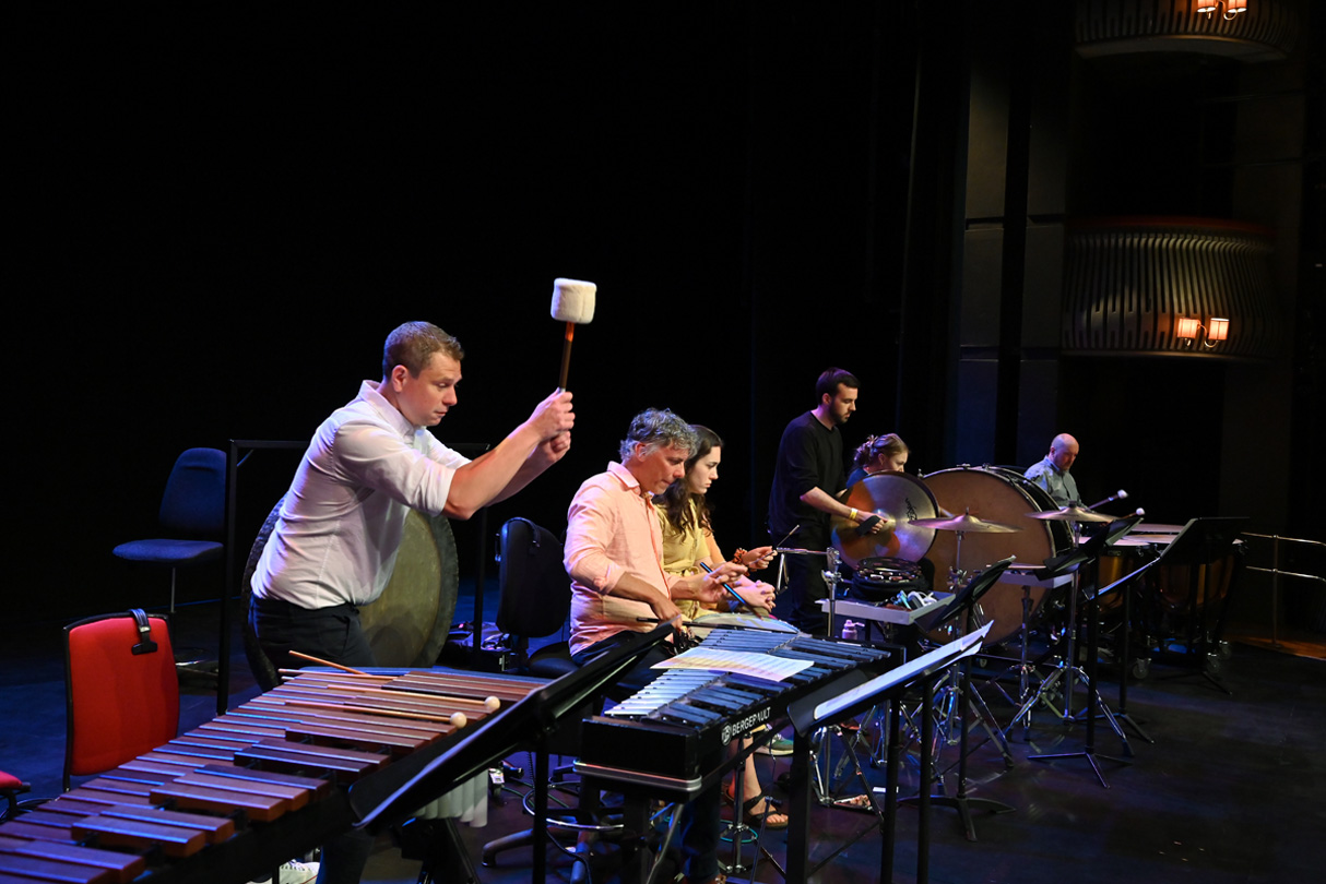 Students performing on marimbas on a stage.